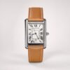 Rectangular silver-tone watch with white dial, black Roman numerals, blue hands, date window, and tan leather strap with white stitching.