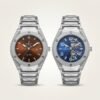 wo silver-tone sports watches with integrated bracelets and faceted bezels, one with a brown dial and one with a blue skeleton dial.