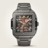 Square grey titanium-style skeleton watch with rose gold hands, visible movement, and rubber-inlaid metal bracelet.