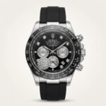 Silver-tone chronograph watch with black dial, diamond hour markers, black tachymeter bezel, and black rubber strap.