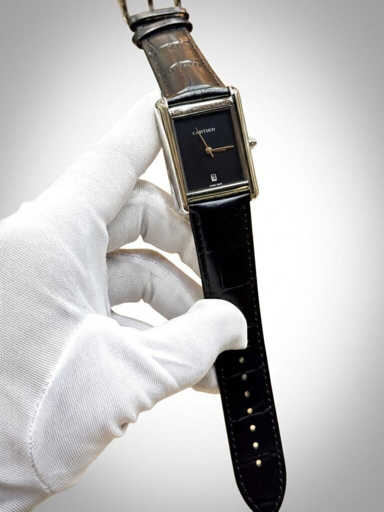 Silver rectangular tank-style watch with white dial, black Roman numerals, and brown leather strap.