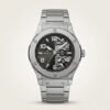 Silver-tone sport watch with black and grey dial, exposed skeleton gears, large Arabic numerals, and stainless steel bracelet.