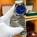 Silver-tone retro style watch with vibrant blue sunburst dial, silver indices, and integrated steel bracelet.