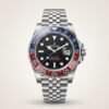 Silver-tone GMT style watch with black dial, red and blue rotating bezel, and jubilee bracelet held in hand.