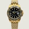 Gold-tone GMT style watch with black dial, black and grey bezel, and gold jubilee bracelet.