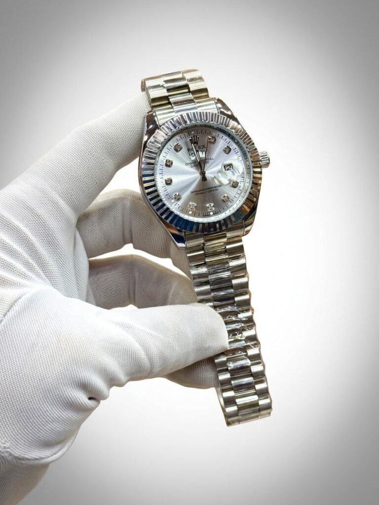 Silver-tone stainless steel watch with fluted bezel, sunburst dial, diamond hour markers, and date window at 3 o'clock.