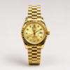 Full gold luxury style watch with champagne sunburst dial, crystal markers, fluted bezel, day window, and gold presidential bracelet.