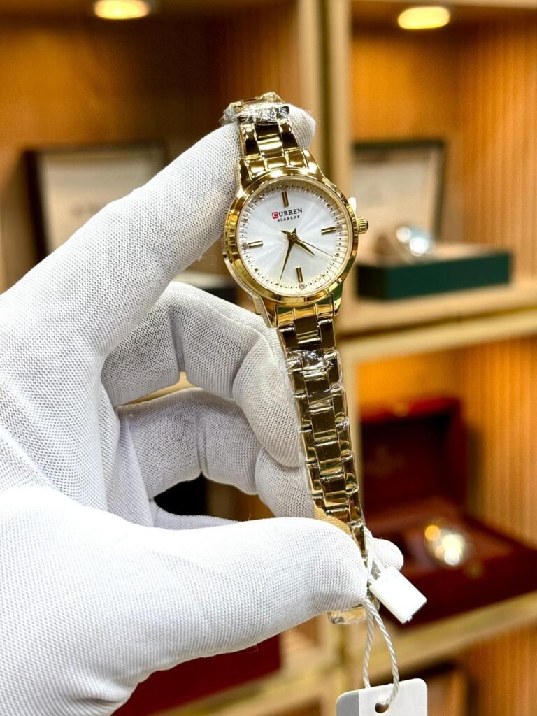 Curren Blanche 9094 women's gold-tone watch with white dial and round stainless steel bracelet.