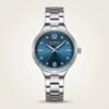 CURREN 9106 women's silver-tone watch with blue sunburst dial and crystal markers.