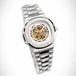 Silver skeleton watch with gold movement, white outer ring, and two-tone integrated bracelet.
