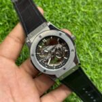 Premium silver-tone skeleton watch with black textured leather strap, exposed gears, and six-screw bezel.