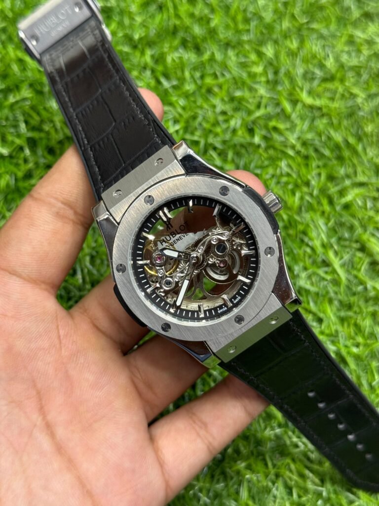 Premium silver-tone skeleton watch with black textured leather strap, exposed gears, and six-screw bezel.
