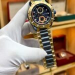 EXTRI two-tone sport chronograph watch with black dial, gold steel bracelet, and working sub-dials.