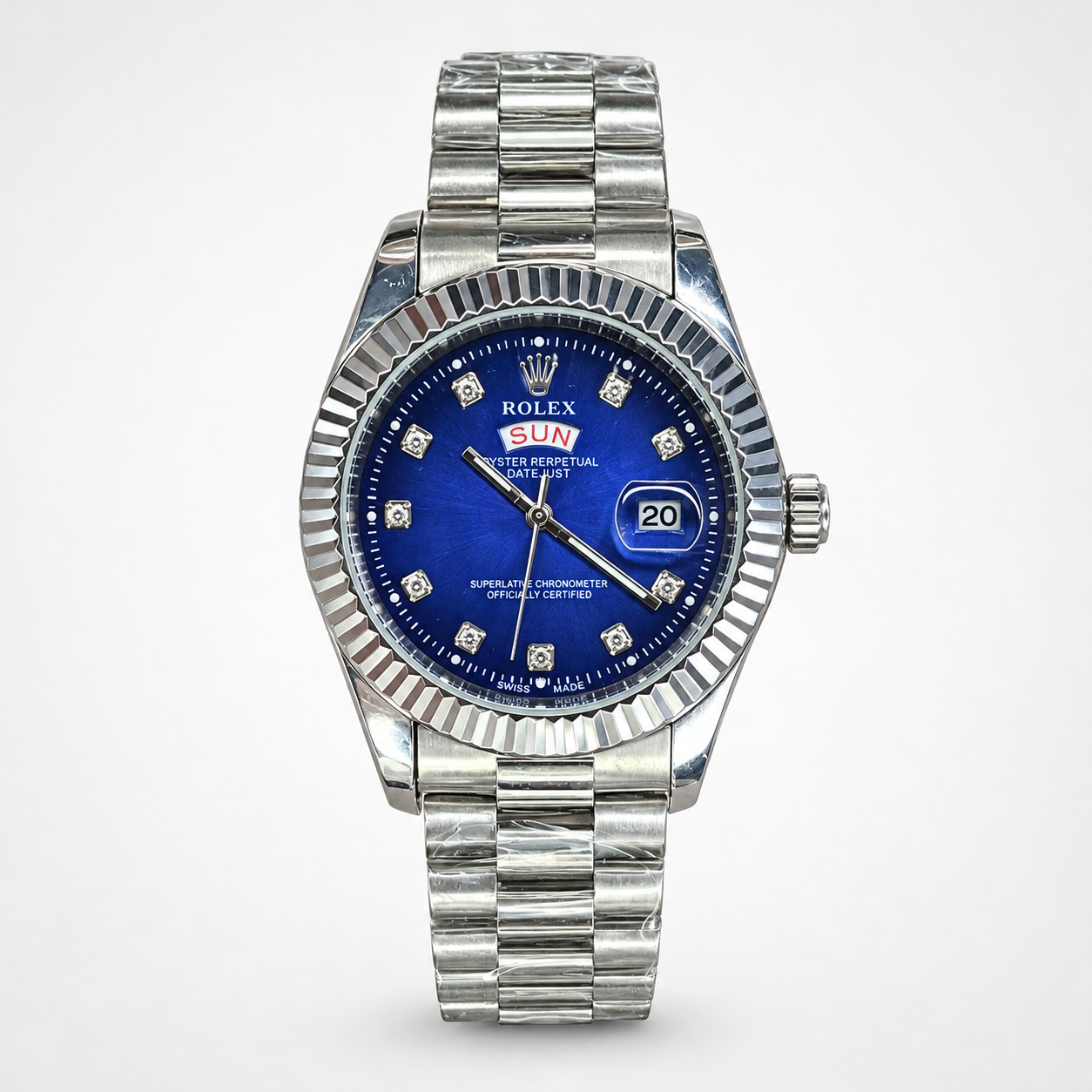 Silver men's luxury watch with blue dial, crystal hour markers, fluted bezel, day-date window, and silver jubilee bracelet.