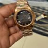 Premium rose gold automatic day-date watch with black Roman numeral dial, fluted bezel, and rose gold president bracelet.