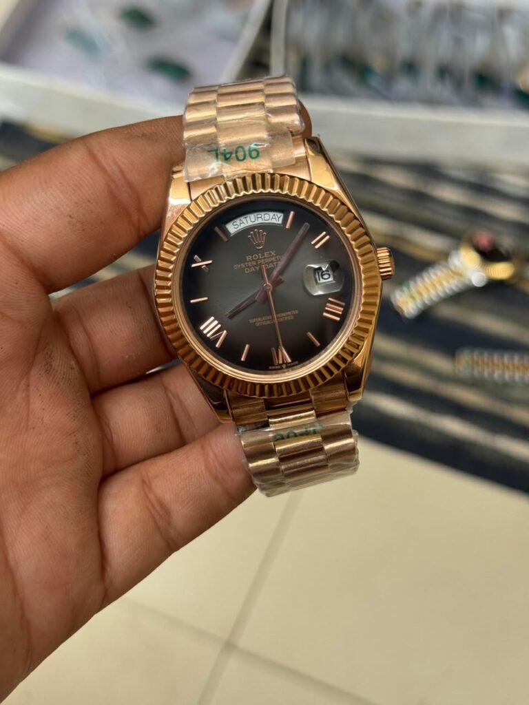 Premium rose gold automatic day-date watch with black Roman numeral dial, fluted bezel, and rose gold president bracelet.